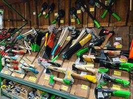 Kyiv, Ukraine - January 03, 2025 Variety of tools and axes displayed on shelves in a hardware store. photo