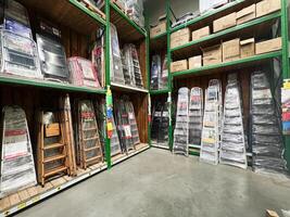 Kyiv, Ukraine - January 03, 2025 Various step ladders displayed on shelves in a hardware supply store photo