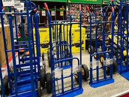 Kyiv, Ukraine - January 03, 2025 Blue hand trucks aligned for sale in a hardware store photo