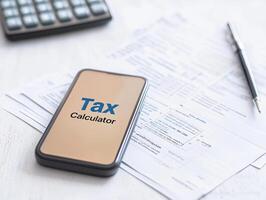 Tax calculator displayed on smartphone with financial documents nearby, showcasing modern technology for easy tax management photo