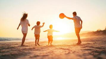 family enjoying sunset at beach, playing frisbee together photo