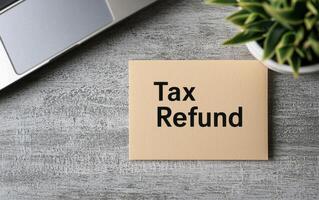 Tax refund note on modern desk with laptop and plant, symbolizing financial relief photo
