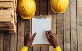 close up of warehouse worker hands holding clipboard and pen, ready to take notes photo