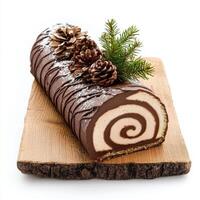 Festive yule log cake with chocolate icing, pinecones, and greenery photo