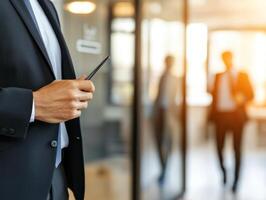 corporate worker holding smartphone in modern office setting, showcasing professionalism and focus photo