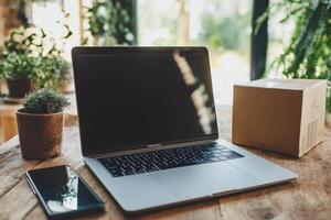 High-Resolution Image of a Laptop and Phone on Table with Cardboard Background Perfect for Tech-Related Content photo