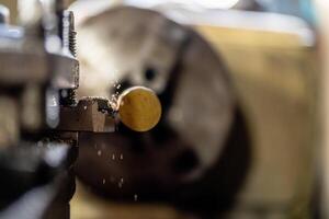The operation of a metal lathe is captured in detail, featuring a steel column rolling during precision machining. photo