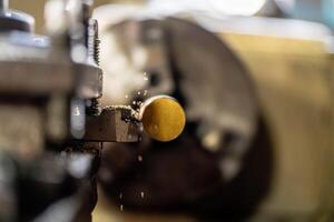 Precision metalworking is demonstrated as a steel column rotates within the lathe machine during operation. photo