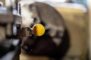 A close up of a machine operating a metal lathe shows a steel column rolling inside the equipment, highlighting processes in the metalworking industry. photo