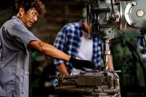 A close up view showcases the steel column rolling within a metal lathe machine during surface refinement. photo