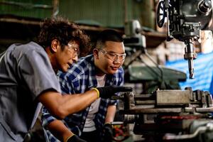 A professional worker operates a lathe grinder machine, refining steel with precision. photo