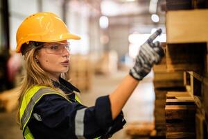 In a workshop, a woman checks wooden products while following safety protocols. photo