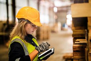 A woman worker evaluates the craftsmanship of wooden products in a secure workshop setting. photo