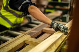 A man in a warehouse cleans timber wood, focusing on preparation and maintenance. photo