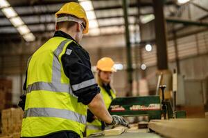 Workers in a carpentry shop focus on quality control for wooden materials and products. photo