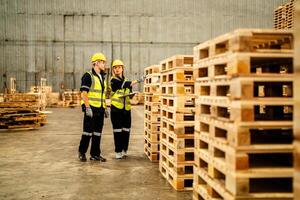 A group of workers inspects wooden materials while cleaning and preparing them for production. photo