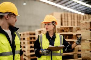 A team of workers inspects wooden materials as part of warehouse operations. photo