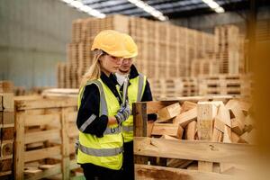 Workers inspect timber materials in a warehouse environment for smart industry operations. photo