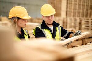 A team of workers inspects the timbers in a warehouse for quality assurance. photo