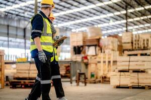 Workers inspect timber materials during a walkthrough to align with factory standards. photo