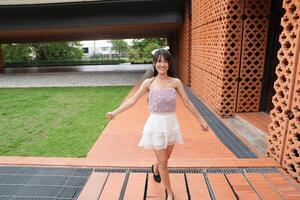 In a calm indoor area, a wom an dances freely near beautiful greenery and a scenic view, radiating harmony and peace. photo