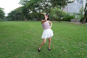 A woman dances happily indoo rs, set against large windows and lush plants, symbolizing harmony and peace. photo