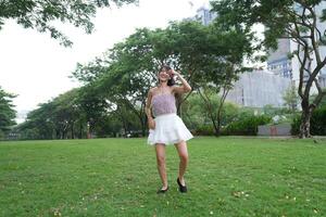 A joyful young woman dances in harmony indoors, with large windows and a scenic view enhancing the freedom and energy photo