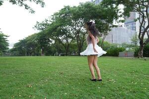 A joyful young woman dances in harmony indoor s, with large windows and a scenic view enhancing the harmony and peace. photo