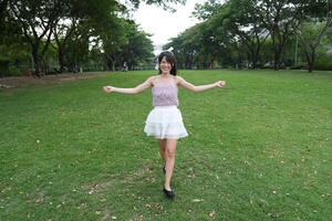 A joyful y oung woman dances in harmony indoors, with beautiful greenery and natural light enhancing the freedom and energy. photo