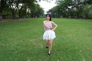 A wo man dances happily indoors, set against large windows and a scenic view, symbolizing harmony and peace. photo