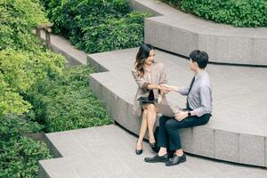 Two business man and woman shake hands outside a modern office building and successful business dealings. professionalism in a corporate setting. reflecting of collaboration and strategic planning. photo