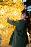 a young woman in front of a christmas trees photo