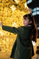 A young girl enjoying a joyful moment in a holiday-themed setting, surrounded by twinkling lights and a warm, vibrant ambiance, capturing the spirit of the festive season. photo