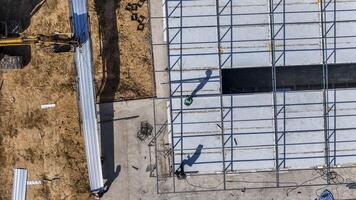 Aerial view of workers placing long metal sheets onto a building fra mework with the aid of heavy machinery, highlighting precision, teamwork, and modern techniques in construction projects. photo