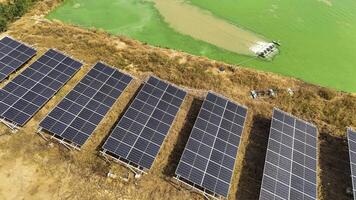 Aerial view of solar panels installed near a w ater body with maintenance equipment and a worker on site, showcasing renewable energy, sustainability, and the integration of solar technology in nature photo