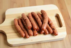 a wooden cutting board with several hot dogs on it photo