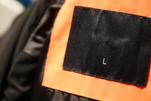 Close-Up View of a Black Label on an Orange Fabric Surface photo
