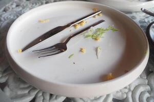 An empty dirty plate with a fork. photo