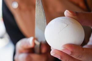 Successfully cracking an egg using a knife in a kitchen environment photo