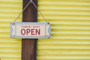 A vibrant and colorful Open Sign displayed on a bright Yellow Background photo