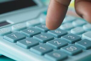 A CloseUp of a Hand Firmly Pressing a Button on a Calculator Device photo