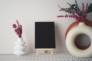 Stylish Decor with Empty Canvas and Dried Flowers on Display photo
