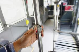 A passengers perspective while holding a metal pole on a city bus during the ride photo