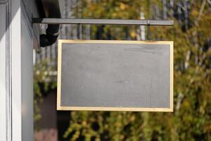 An empty chalkboard sign is currently hanging outside, awaiting messages photo