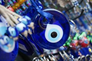 a bunch of blue evil eye keychains hanging on a shelf photo