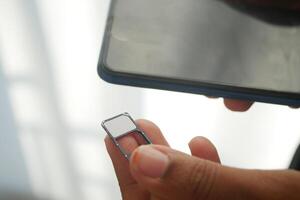 Inserting a SIM Card Into a Smartphone Device for Connectivity Setup photo