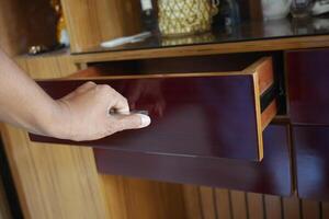 man's hand open drawer wooden in cabinet photo