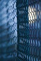 Abstract shot of a green wire mesh fence with defocusing effect and light effects in the background. photo