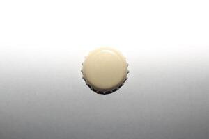 A beige beer cap on lightness gradient. photo