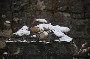 Snow on stones of a pillar. photo